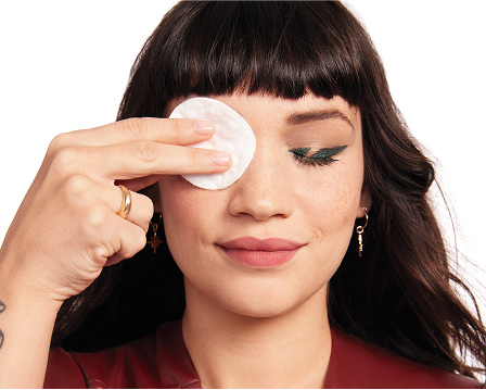 Female model applying a pad with Mary Kay Oil Free Eye Makeup Remover to her eye